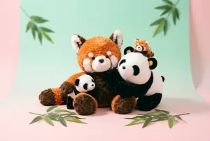 Famille de peluches panda et panda roux sur fond pastel